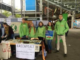 Engagierte von Greenpeace Freiburg stehen am Infostand