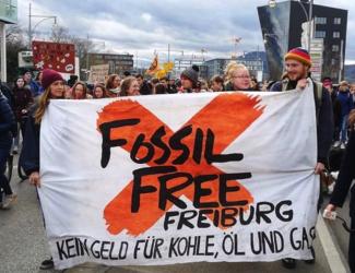 Fossil Free Aktivistis mit Banner