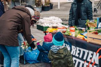 zwei kleine Kinder bekommen gerettete Lebenmittel geschenkt